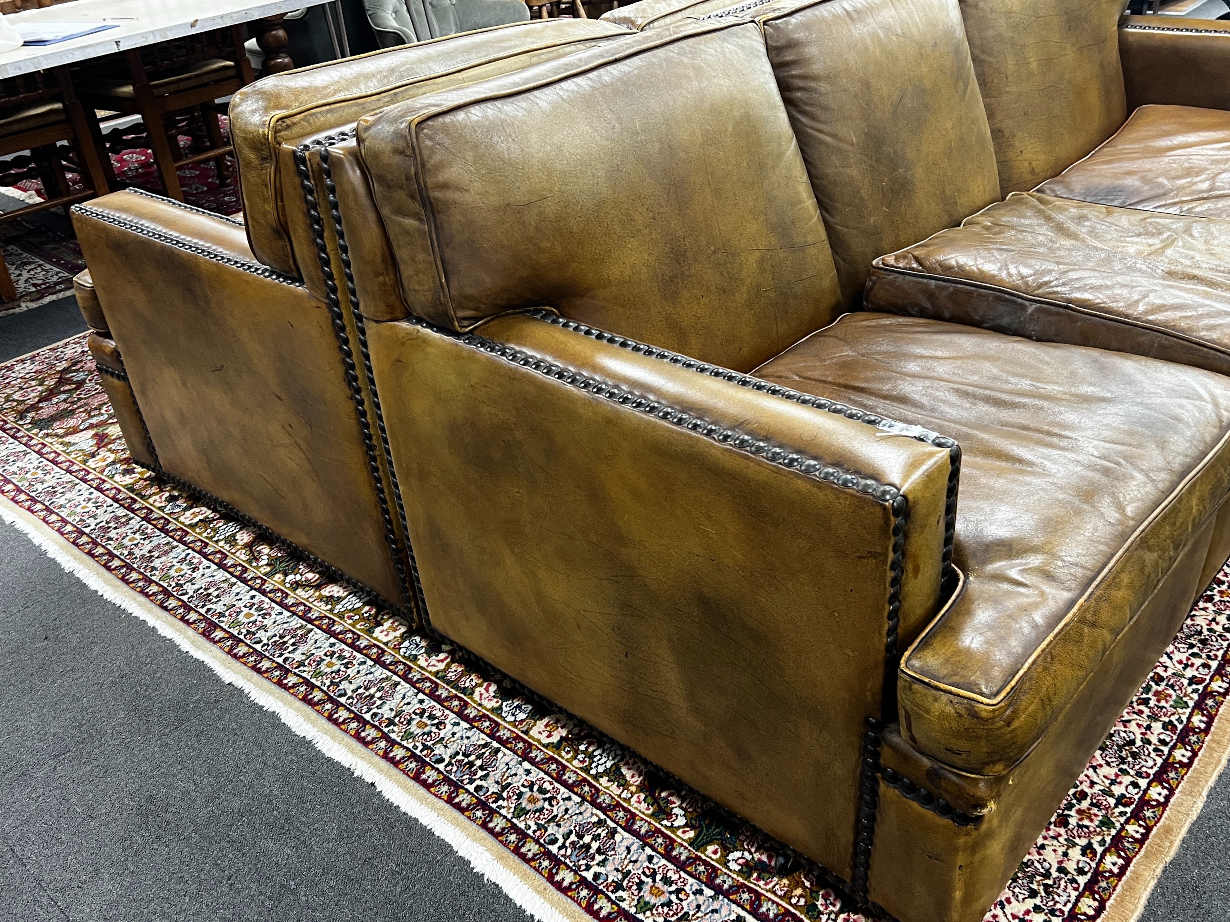 A pair of brown leather brass studded three seater settees, length 200cm, depth 90cm, height 84cm